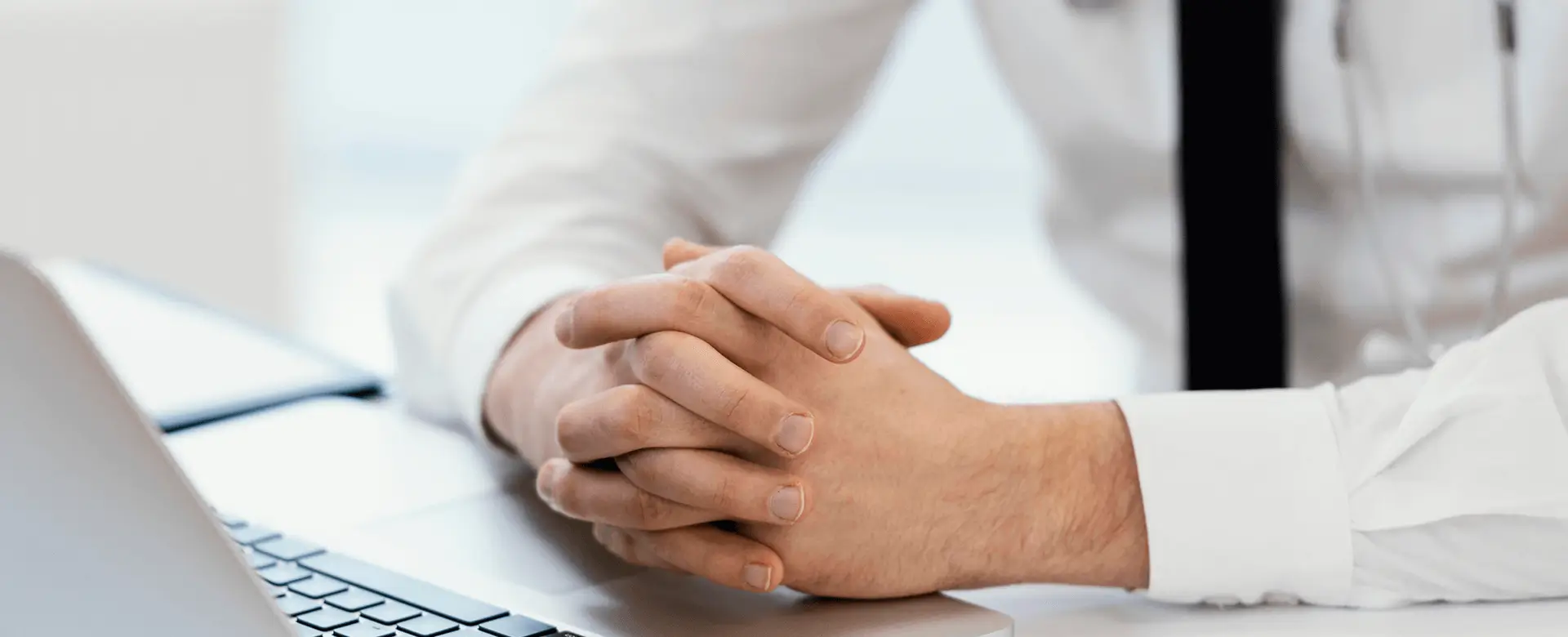 Professional with Hands Folded on Desk - Contact Us Page